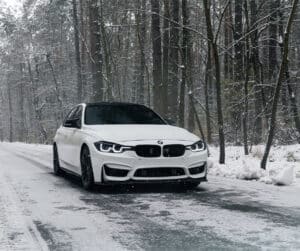 Expert BMW Winter Care Tips | Legend Motor Works Auto Service. White bmw 3 series f30 driving on winter snowy road.