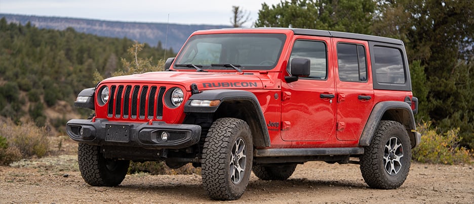 Jeep Service and Repair near me in Colorado Springs, CO with Legend Motor Works. Image of a red Jeep Wrangler Rubicon parked on a dirt road, showcasing reliable service and repair from Legend Motor Works.
