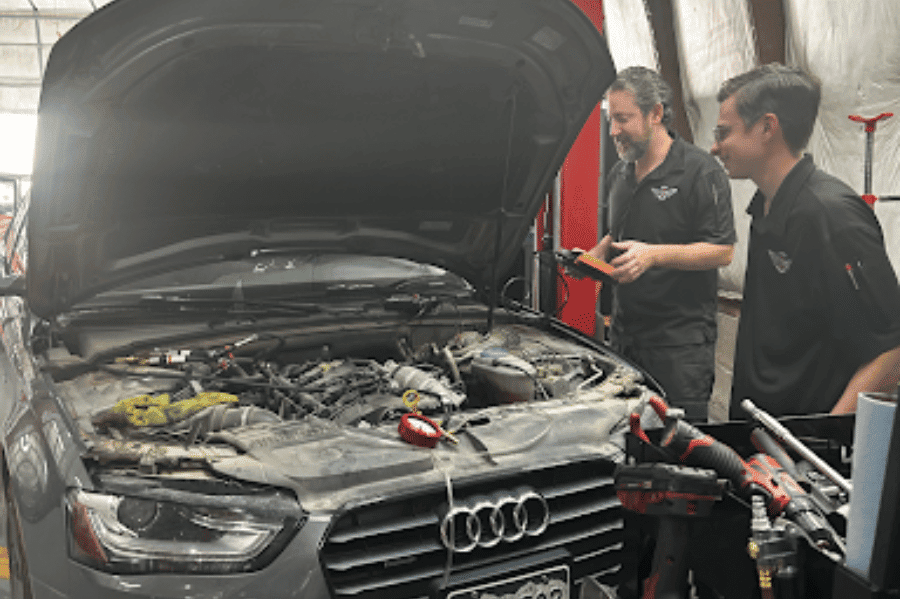Best auto repair near me in Colorado Springs, CO. with Legend Motor Works. Image of two male mechanics performing diagnostic testing on a newer model audi in shop.